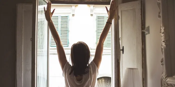 A woman is stretching in front of a window