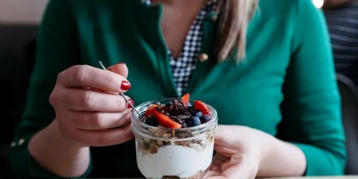 Woman holding a yogurt pot