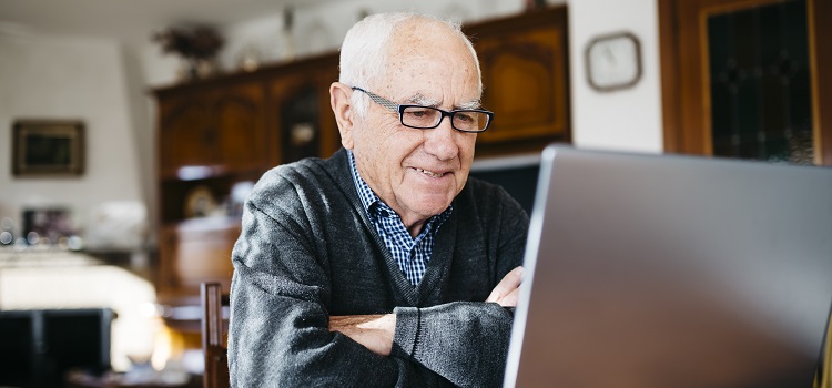 An older man sat at a laptop