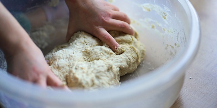 a child's hand kneading dough