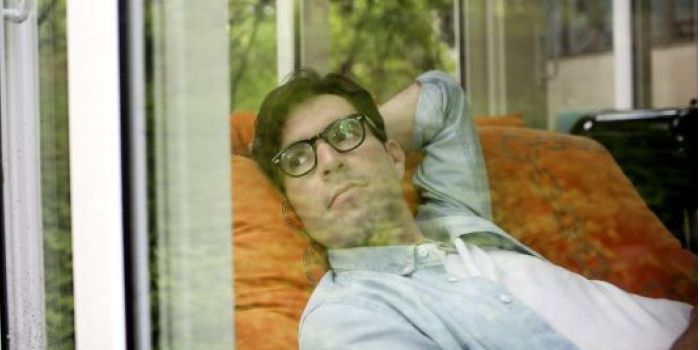 a man lying down, looking out of the window