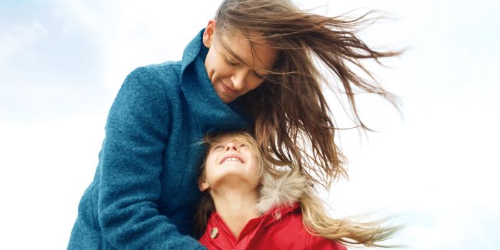 woman holding a girl on a windy day
