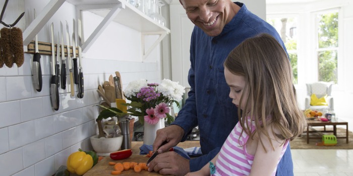 a father and daughter cooking in the kitchen