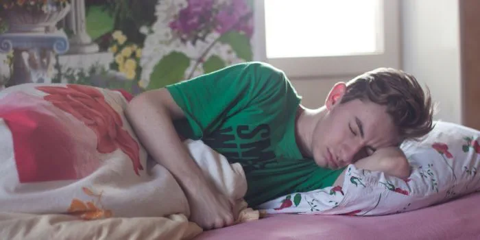 A teenage boy sleeping in bed