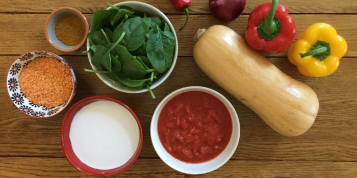 vegetables and bowls of coconut milk, lentils, spinach, chopped tomatoes