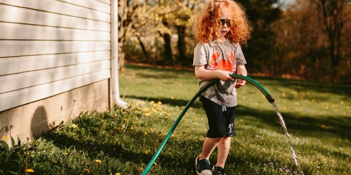 A child playing with a hose pipe