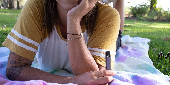 person with a vape in the garden