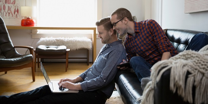 two men looking at a laptop
