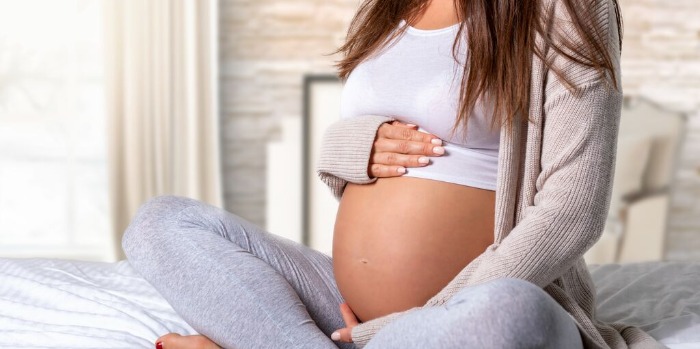 A pregnant woman holding her belly