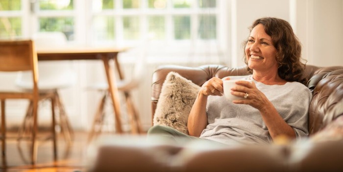 A woman relaxing with a cup of coffee on a sofa