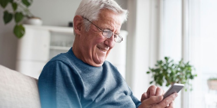 An elderly man looking at his phone