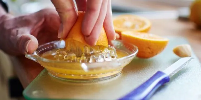 person juicing an orange