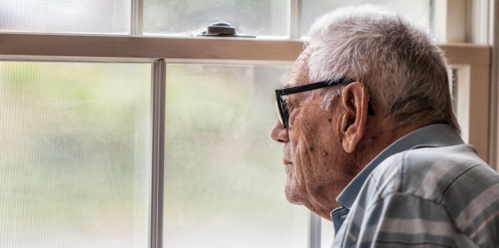 an older man looking through a window