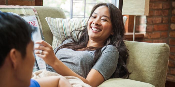 woman lying on a couch reading