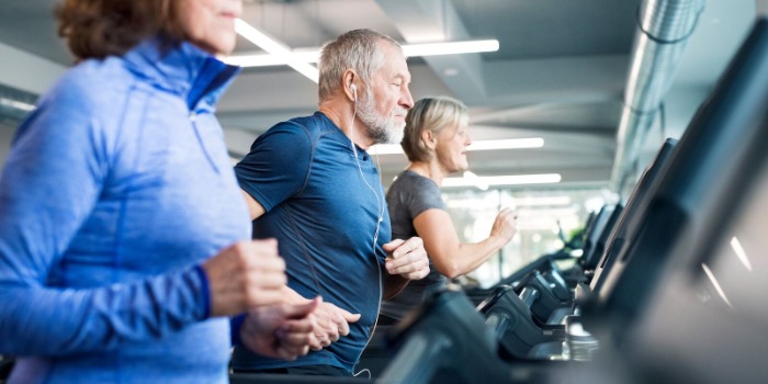 People exercising on a row of treadmills