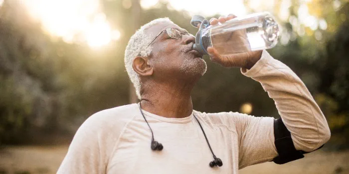 An adult drinking water from a bottle
