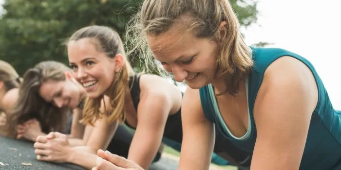 group of women doing plank exercise outdoors