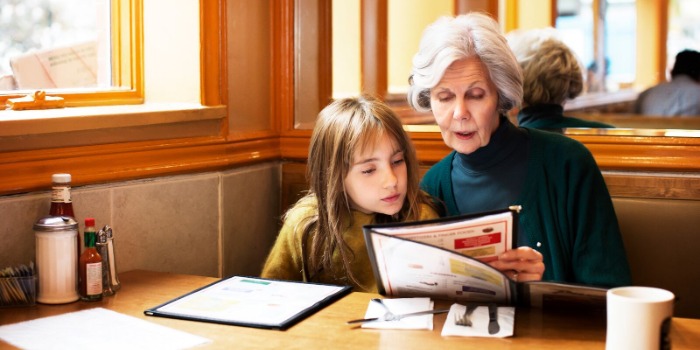 older woman and child looking at restaurant menu