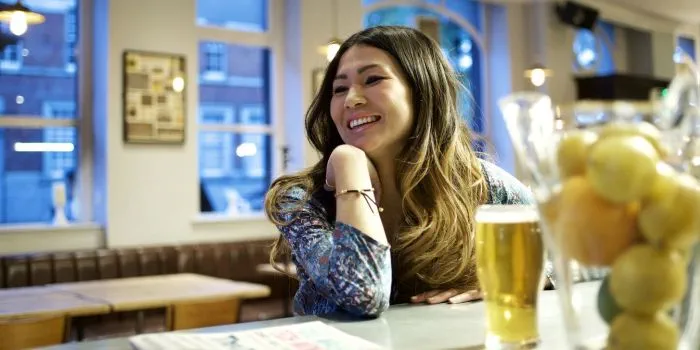 Photo of a woman drinking alcohol in a bar