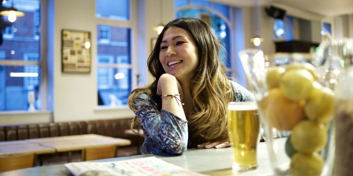 woman smiling, sitting in a bar