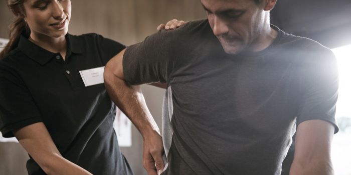 physiotherapist helping a patient with lower back pain