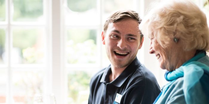 two people laughing over a glass of wine