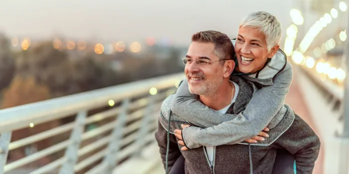 two people having fun, piggy back on a bridge