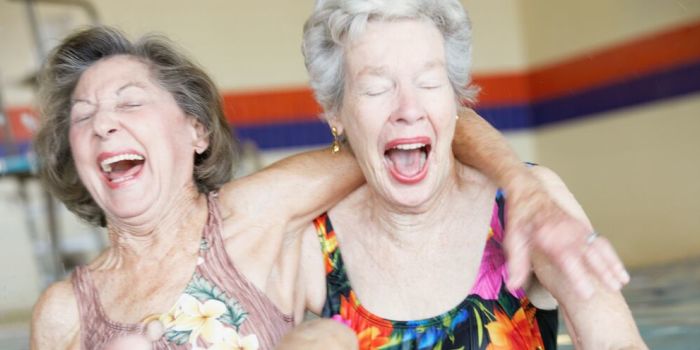 two older women having a laugh in the pool