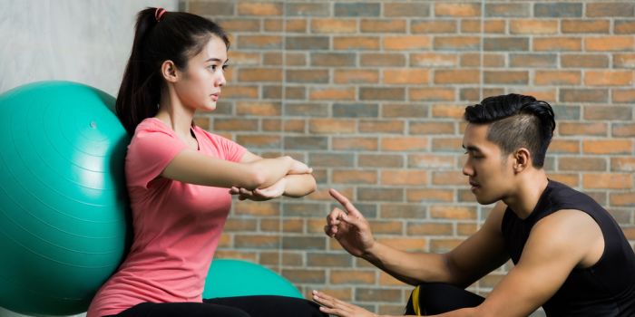 person doing wall sit exercises on a yoga ball