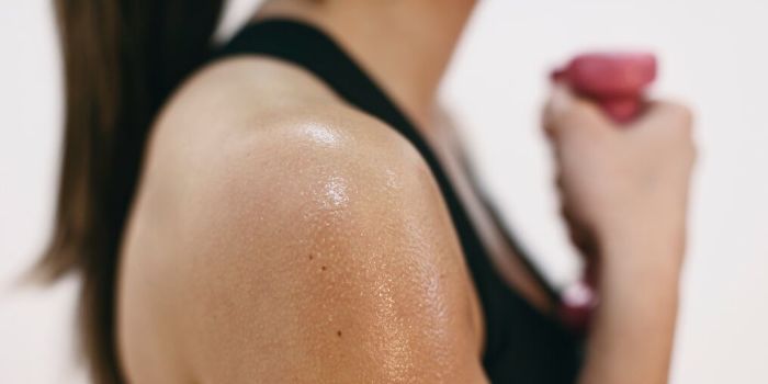 woman working out with dumb bell in hand