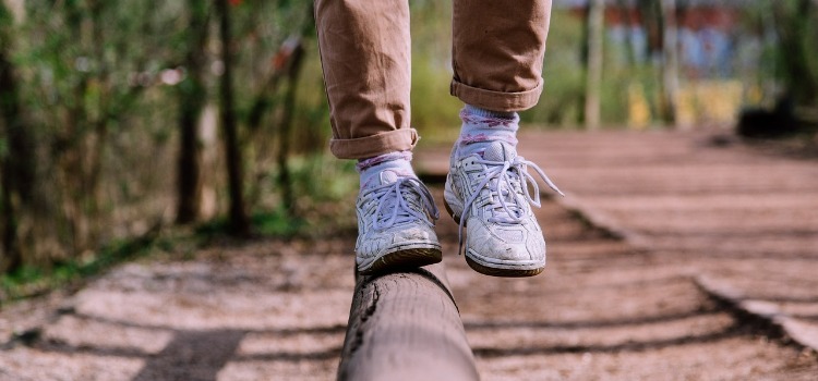 person balancing on a log