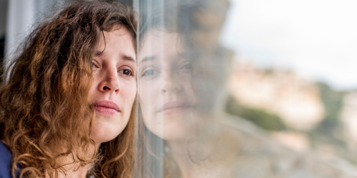 worried person looking out window