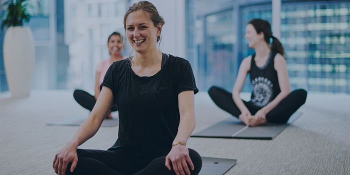 group of people practising yoga on a mat