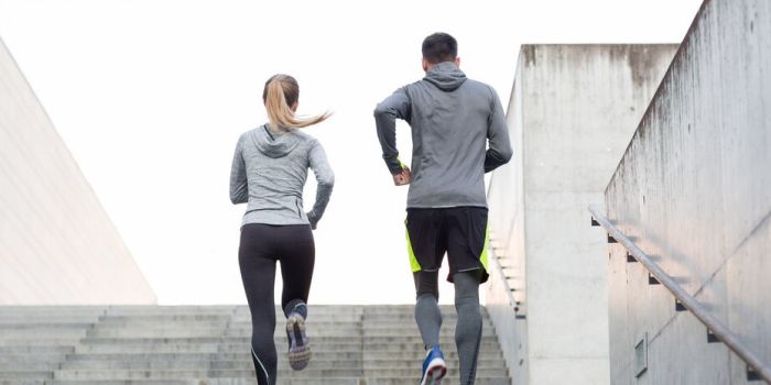 Two people running up some stairs