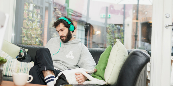 man relaxing on the sofa with headphones on