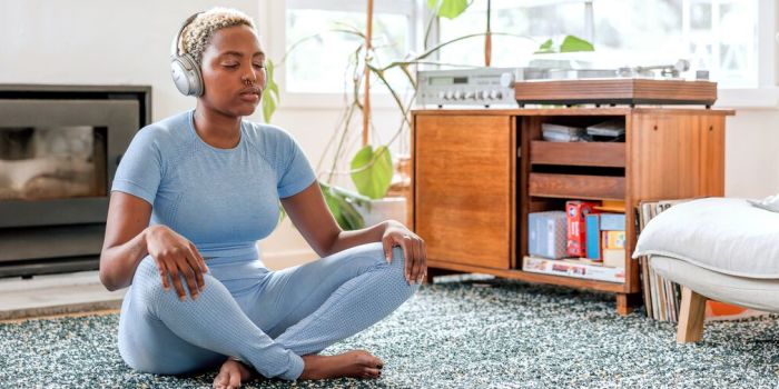 person meditating at home with headphones on