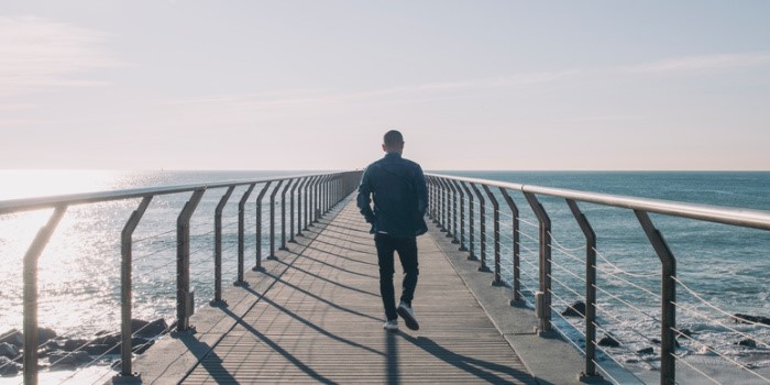 person walking alone on a pier
