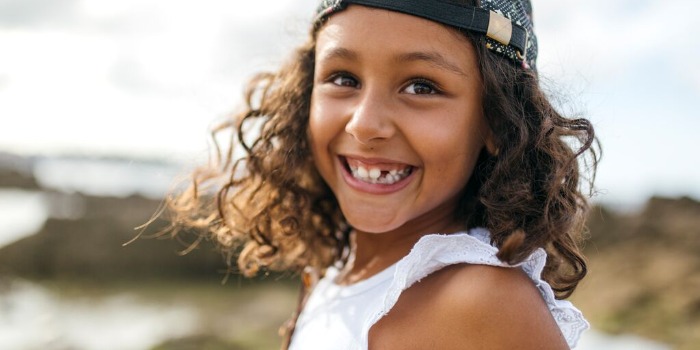 child with a missing tooth and a big smile