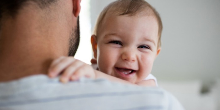 dad carrying a smiling baby