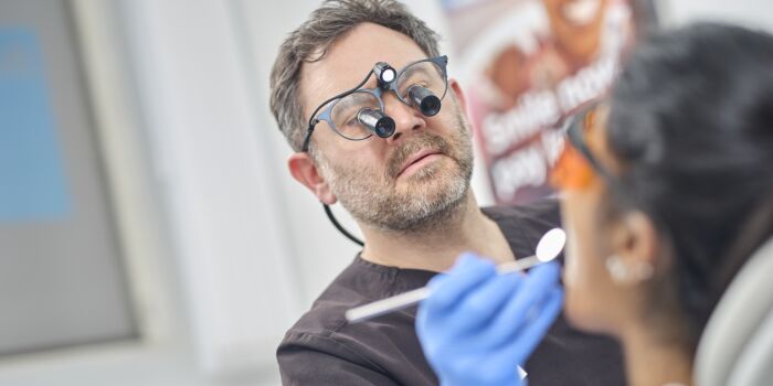 Dentist with patient checking teeth