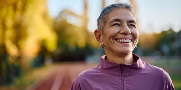 woman smiling whilst taking a break from running