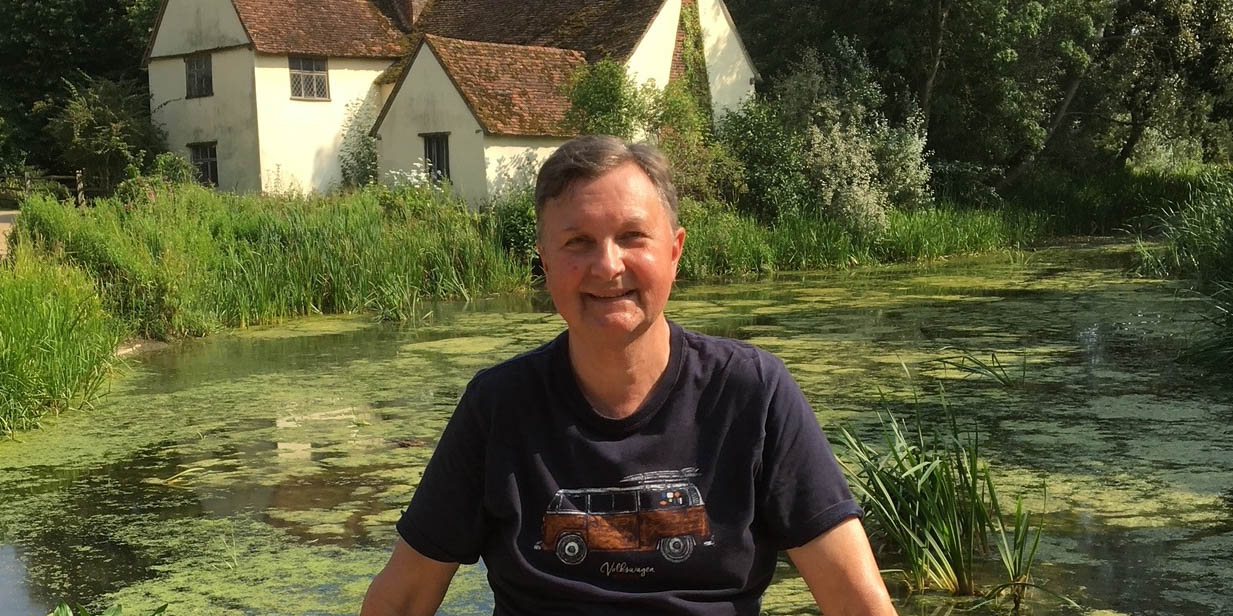 man posing for a picture outside garden