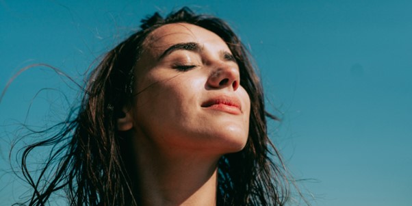 person with eyes closed in outdoor sun