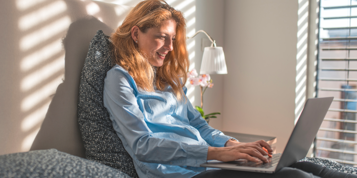 person using laptop on bed