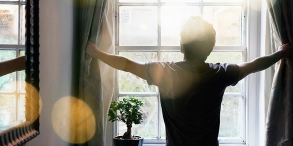 person letting sun in the room