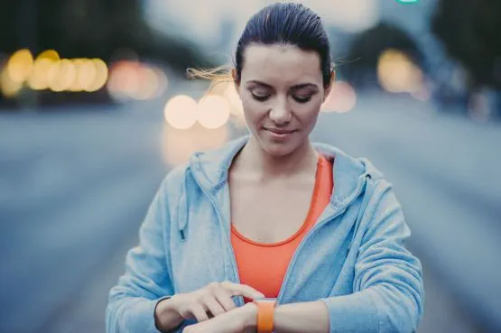A female runner sets her watch