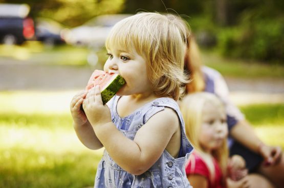 Young girl eating a slice of watermelon