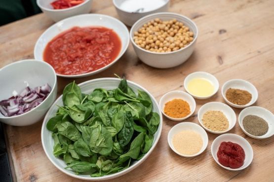 bowls of tomato, spinach, chickpeas, onions and spices