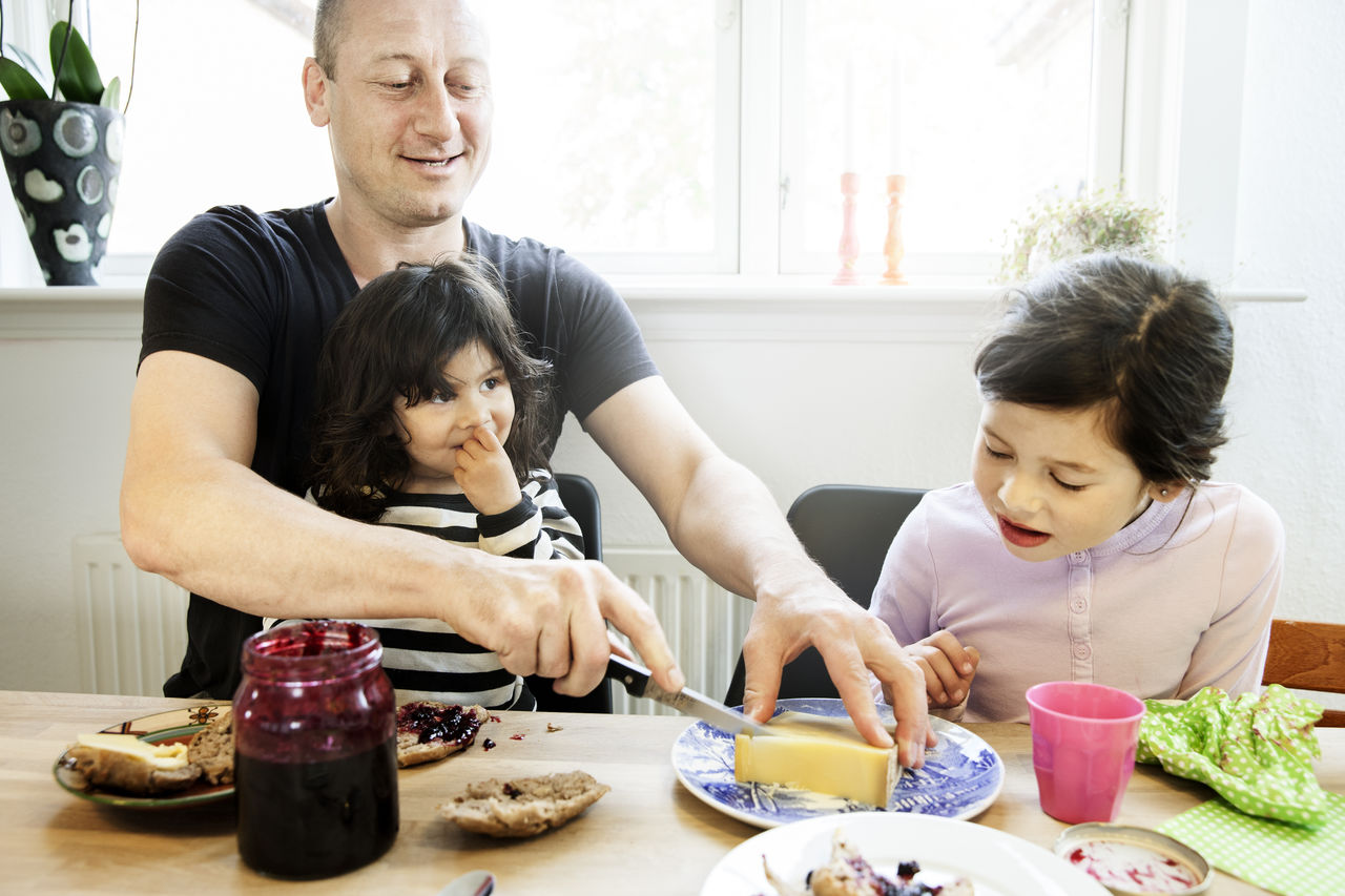 An image showing a Dad having lunch with his children An image showing a Dad having lunch with his children