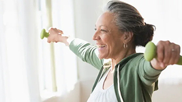 Older adult exercising with light weights at home